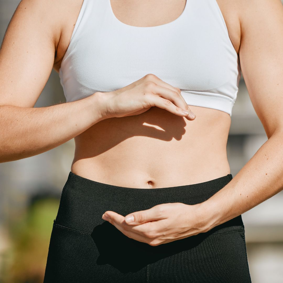 a women holding her hands around her tummy