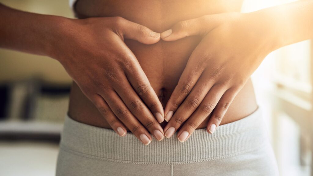 a woman pressing her palms against her stomach